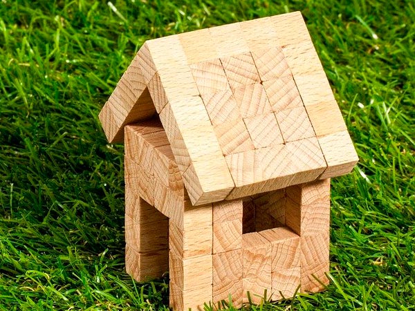 Casa de madeira de brinquedo sobre gramado verde - Direito de Preferência  Imóvel